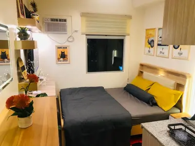 a small bedroom with a bed and a desk at Dos Staycation Urban Deca Cubao in Manila