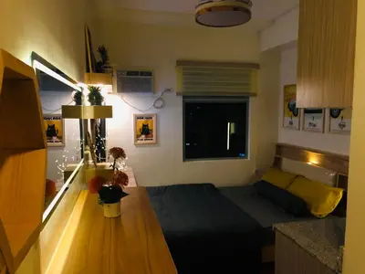 a small room with a bed and a table at Dos Staycation Urban Deca Cubao in Manila