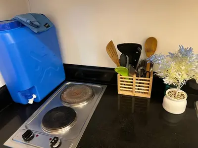 a kitchen counter with a stove and a counter top withtools at Greece Theme Boni MRT Train Edsa 1BR with Netflix Fast Internet Pool Light Mall in Manila