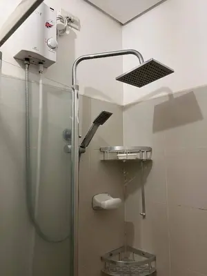 a shower in a bathroom with a glass shower stall at Greece Theme Boni MRT Train Edsa 1BR with Netflix Fast Internet Pool Light Mall in Manila