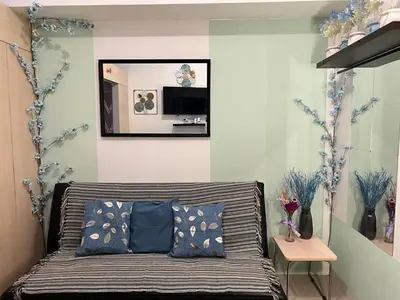 a bedroom with a bed with a mirror on the wall at Greece Theme Boni MRT Train Edsa 1BR with Netflix Fast Internet Pool Light Mall in Manila