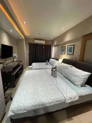 a large bedroom with two beds and a desk at Staycation Near Mall of Asia in Manila
