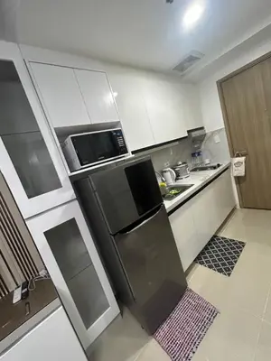 a small kitchen with a refrigerator and a microwave at E&T staycation in Manila