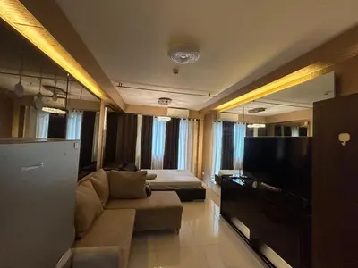 a living room with a couch and a flat screen tv at E&T staycation in Manila