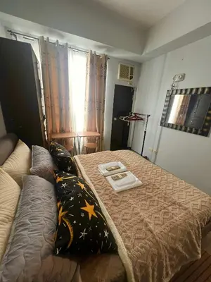 a small bedroom with a bed and a couch at Mezza Residences in Manila