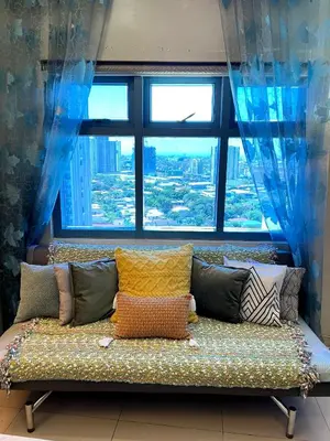a couch with pillows in front of a large window at Osaka Japan Theme Greenbelt Glorieta Makati Big Unit Loft 50sqm Free Pool Gym Netflix in Manila