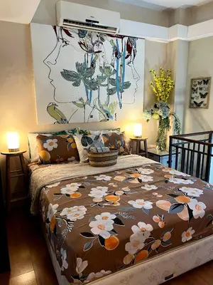 a bedroom with a large bed with a floral bedspread at Osaka Japan Theme Greenbelt Glorieta Makati Big Unit Loft 50sqm Free Pool Gym Netflix in Manila