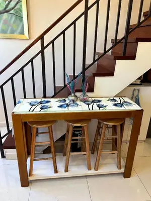 a wooden table with two stools under a staircase at Osaka Japan Theme Greenbelt Glorieta Makati Big Unit Loft 50sqm Free Pool Gym Netflix in Manila
