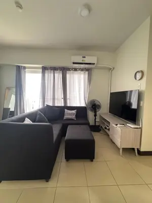 a living room with a blue couch and a tv at J Suite in Manila