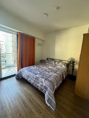 a bedroom with a bed in a room with a window at J Suite in Manila