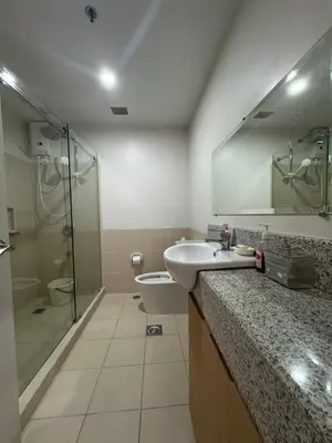 a bathroom with a sink and a shower and a toilet at J Suite in Manila