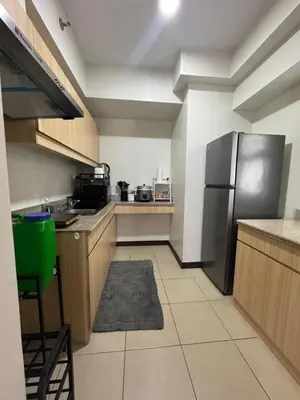 a kitchen with a stainless steel refrigerator and cabinets at J Suite in Manila
