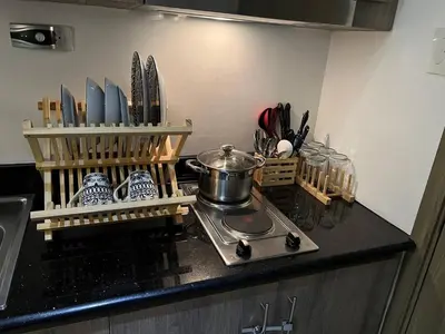 a kitchen counter with a stove and some utensils at Japan Vibe Shaw MRT Train EDSA 1BR with Veranda Netflix Internet Pool View in Manila