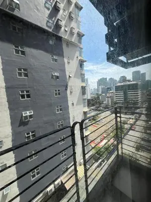 a tall building with a view of a train yard at A Venue Residences 80N in Manila