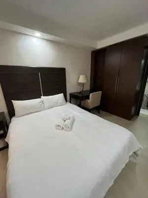 a bedroom with a large white bed with towels on it at A Venue Residences 80N in Manila