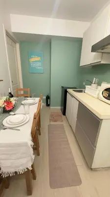 a kitchen with a table with chairs and a counter top at 2- Bedroom Condo in Metro Manila - Azure Beach in Manila