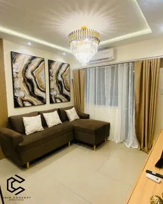 a living room with a couch and a chandelier at Serenity Suite Smart Condo 2 BR Balcony in Manila