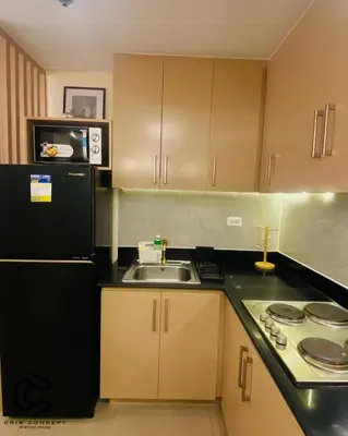 a kitchen with a black refrigerator and a sink at Serenity Suite Smart Condo 2 BR Balcony in Manila