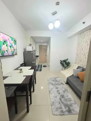 a living room with a table and a couch at Sea Affordable staycation in Manila