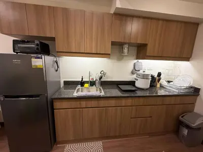 a kitchen with a refrigerator and a sink at 1BR Luxury Apartment The Camden Place in Manila