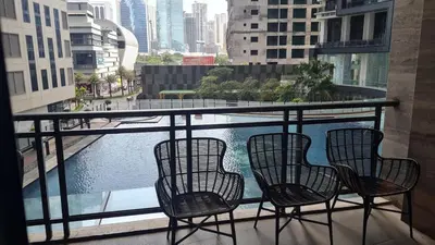 three chairs on a balcony with a view of a body of water at The Oasis in Knigthsbridge Residence, Makati in Manila