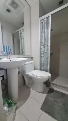 a bathroom with a white toilet and a sink at The Oasis in Knigthsbridge Residence, Makati in Manila