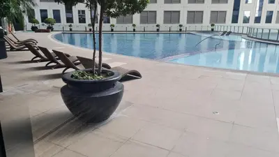 a potted tree in a pot next to a swimming pool at The Oasis in Knigthsbridge Residence, Makati in Manila