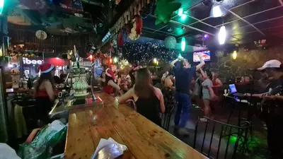 a crowd of people in a bar with christmas hats at The Oasis in Knigthsbridge Residence, Makati in Manila