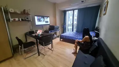 a woman sitting on a couch in a living room at The Oasis in Knigthsbridge Residence, Makati in Manila
