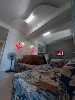 a bedroom with a bed and a large mirror at Sea Residences Mall of Asia in Manila