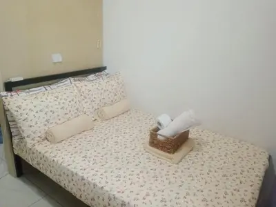 a bedroom with a bed with a basket of towels at Sea Residences Mall of Asia in Manila
