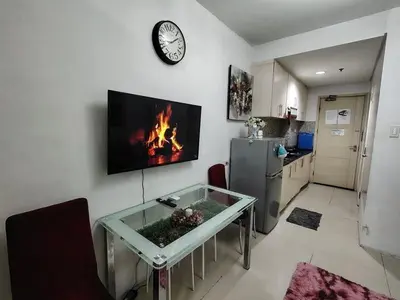 a living room with a table and a fire in the wall at Sea Residences Mall of Asia in Manila