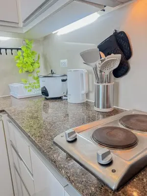 a kitchen with a counter top with utensils at nJoy! Tropical Breeze at Venice Grand Canal in Manila