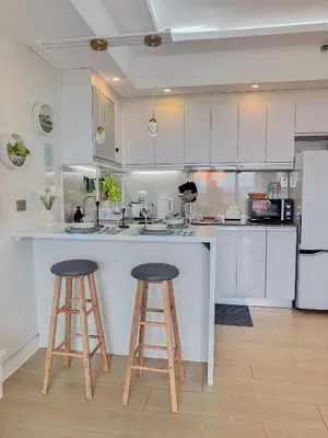 a kitchen with two bar stools and a counter top at nJoy! Tropical Breeze at Venice Grand Canal in Manila