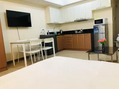 a kitchen with a table and a refrigerator at Charming 1BR with Balcony near Venice mall&BGC in Manila
