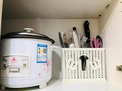 a toaster sitting next to a container of kitchen utensils at Charming 1BR with Balcony near Venice mall&BGC in Manila
