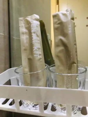 two cups on a white shelf with a bottle at Charming 1BR with Balcony near Venice mall&BGC in Manila