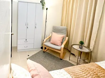 a bedroom with a chair with a pink pillow on it at Kasara Urban Resort Residences by Amari Staycations in Manila