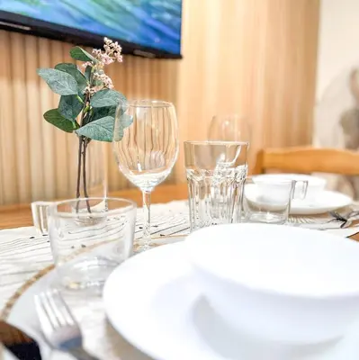 a table with glasses and a vase with a plant on it at Kasara Urban Resort Residences by Amari Staycations in Manila