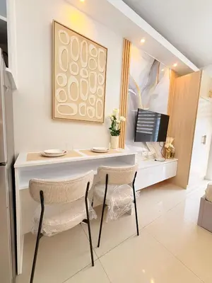 a desk with two chairs and a computer in a room at Shell Residences Mall of Asia Caitlin's Place in Manila