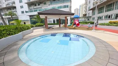 a swimming pool with a gazebo and a playground at Cosy Makati Penthouse Studio with Great View in Manila