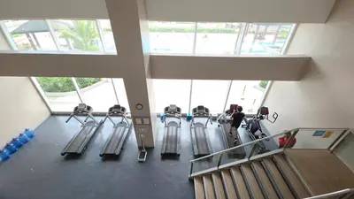 a group of people on machines in a gym at Cosy Makati Penthouse Studio with Great View in Manila