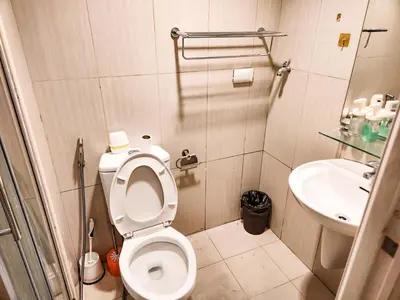 a small bathroom with a toilet and a sink at Amazing Poolside 1br MOA Netflix 100mbps fiber in Manila