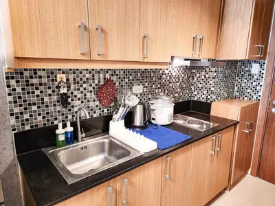 a kitchen with a sink and a counter top at Amazing Poolside 1br MOA Netflix 100mbps fiber in Manila