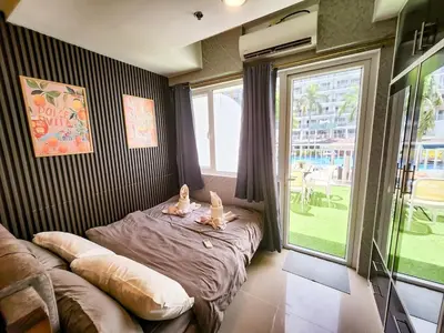a bedroom with a bed and a large window at Amazing Poolside 1br MOA Netflix 100mbps fiber in Manila