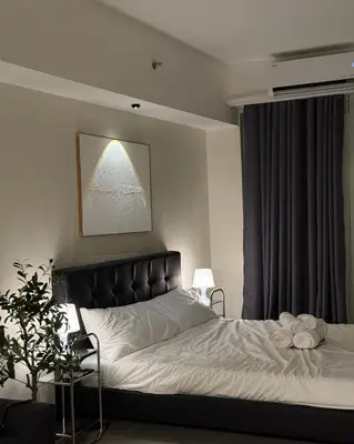 a bedroom with a large bed with white sheets at Bruné - Parañaque in Manila