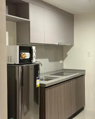 a kitchen with a stainless steel refrigerator and a microwave at Bruné - Parañaque in Manila