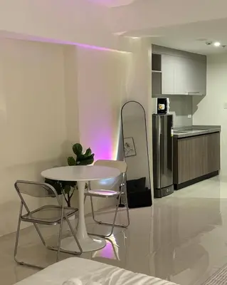 a kitchen with a table and chairs and a refrigerator at Bruné - Parañaque in Manila
