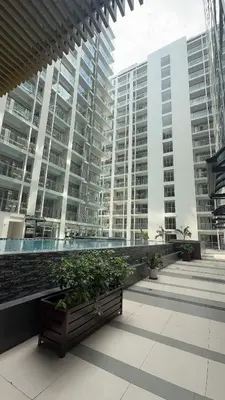a bench in front of some tall buildings at Bruné - Parañaque in Manila