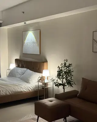 a bedroom with a bed and a chair and a window at Bruné - Parañaque in Manila